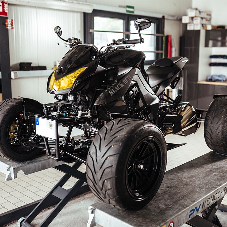 Tuner Aram verschraubt den Seitenspiegel an seinem schwarzen Quad Black Bull