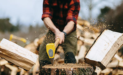 Mann beim Holzspalten mit einem Ochsenkopf Spalthammer